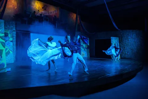 Dancers in flowing costumes perform in blue stage light at Occidental Tamarindo.