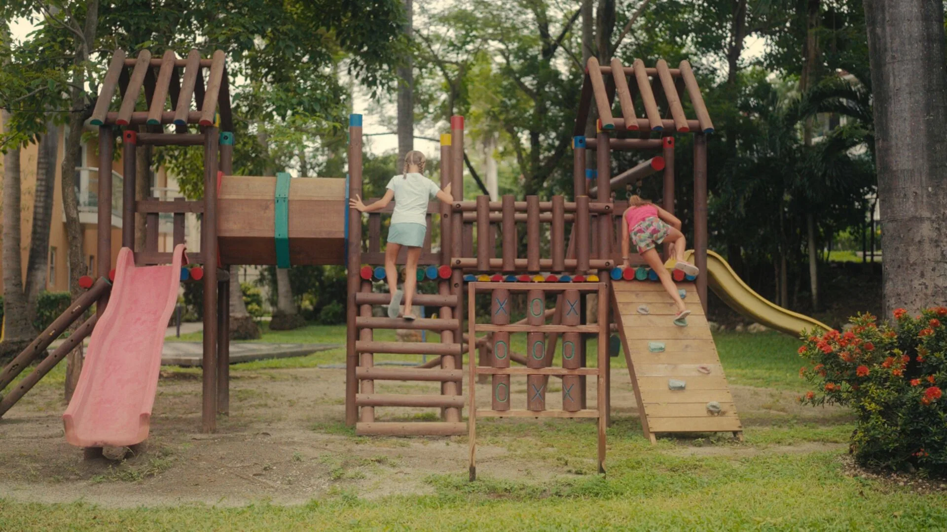 Children climbing on a wooden playground with slides at Occidental Tamarindo.