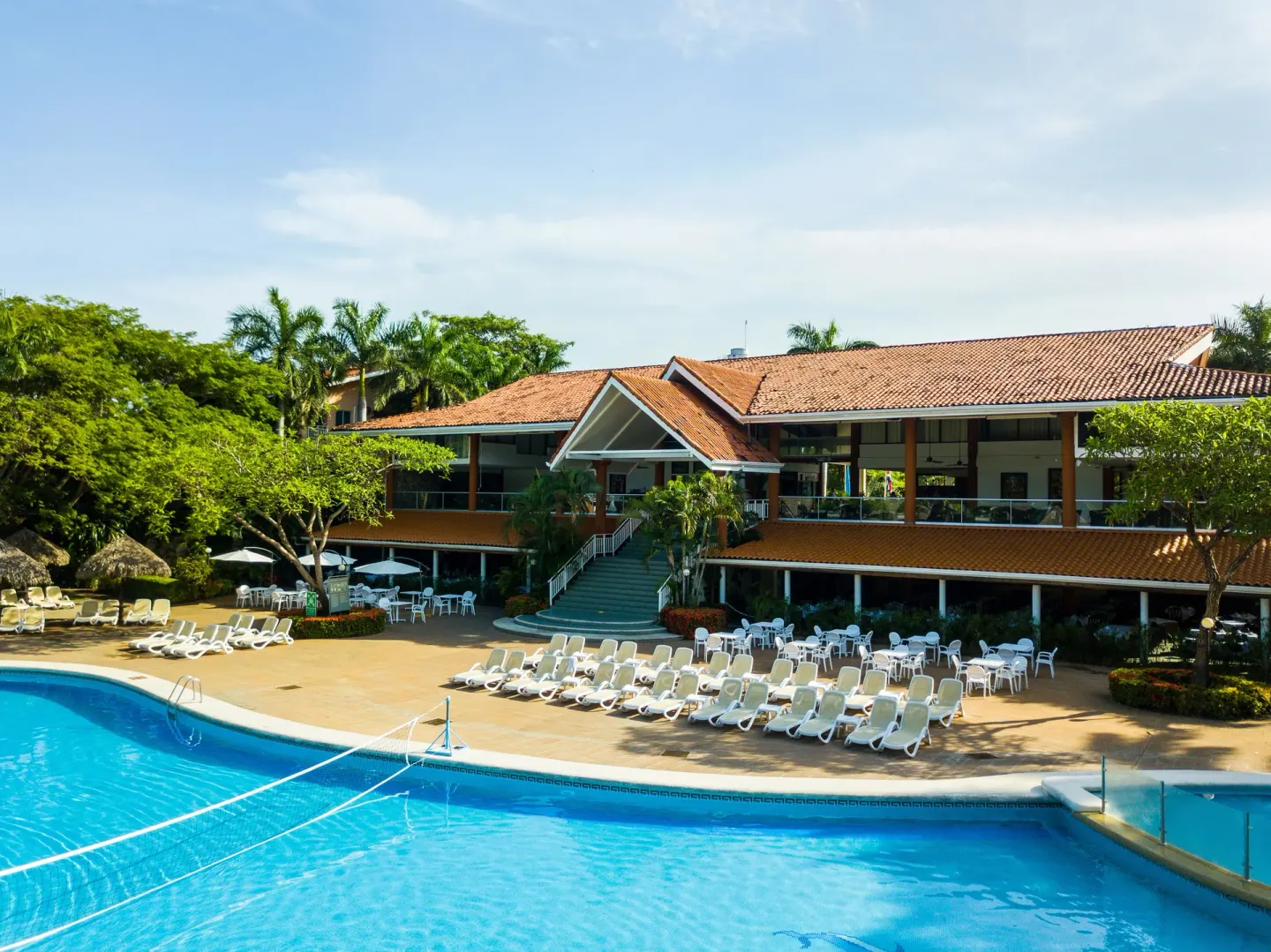 Resort pool, lounge chairs, and terracotta-roofed building at Occidental Tamarindo.