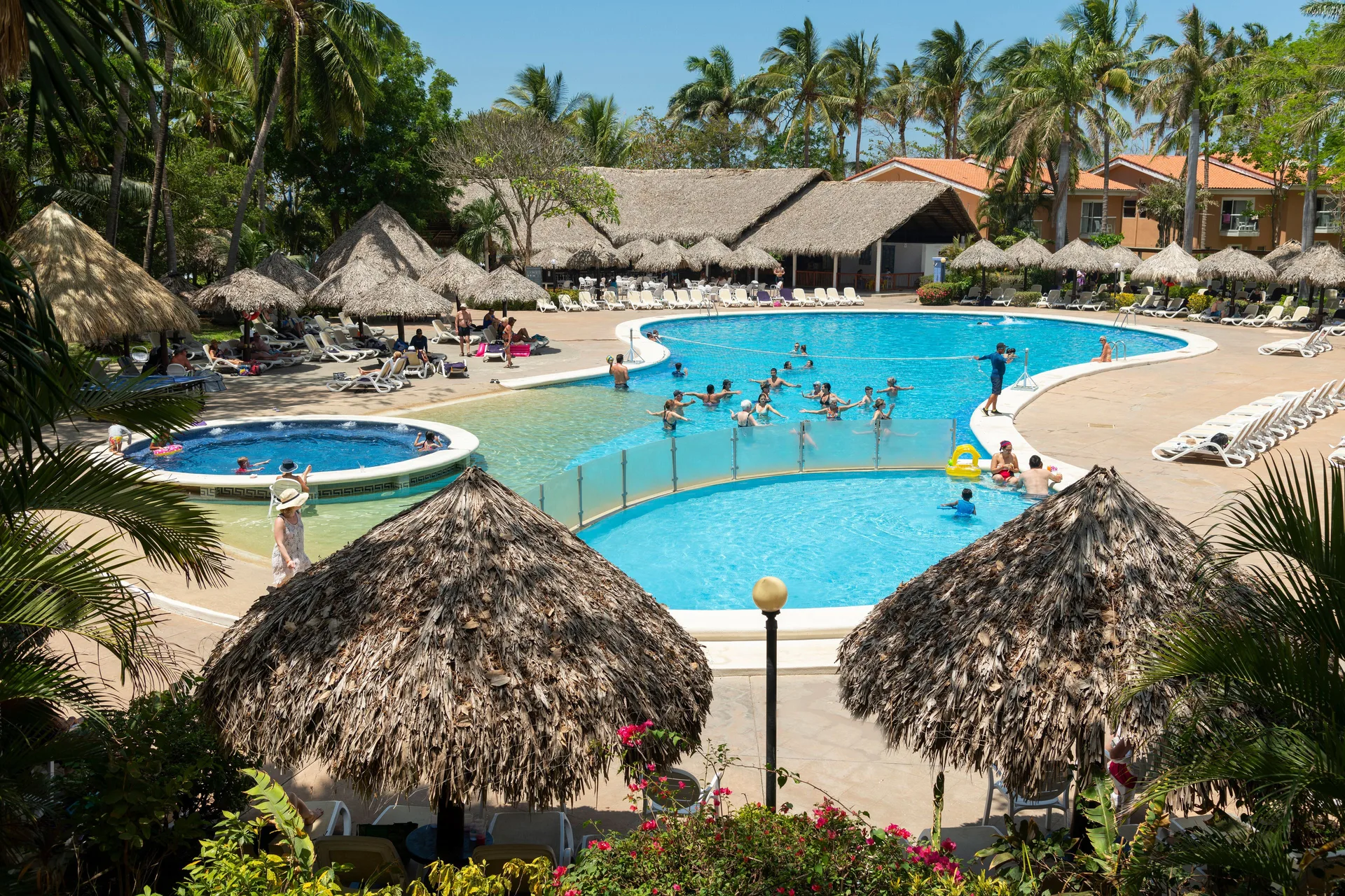 Large resort pool with palapas and lounge chairs at Occidental Tamarindo.