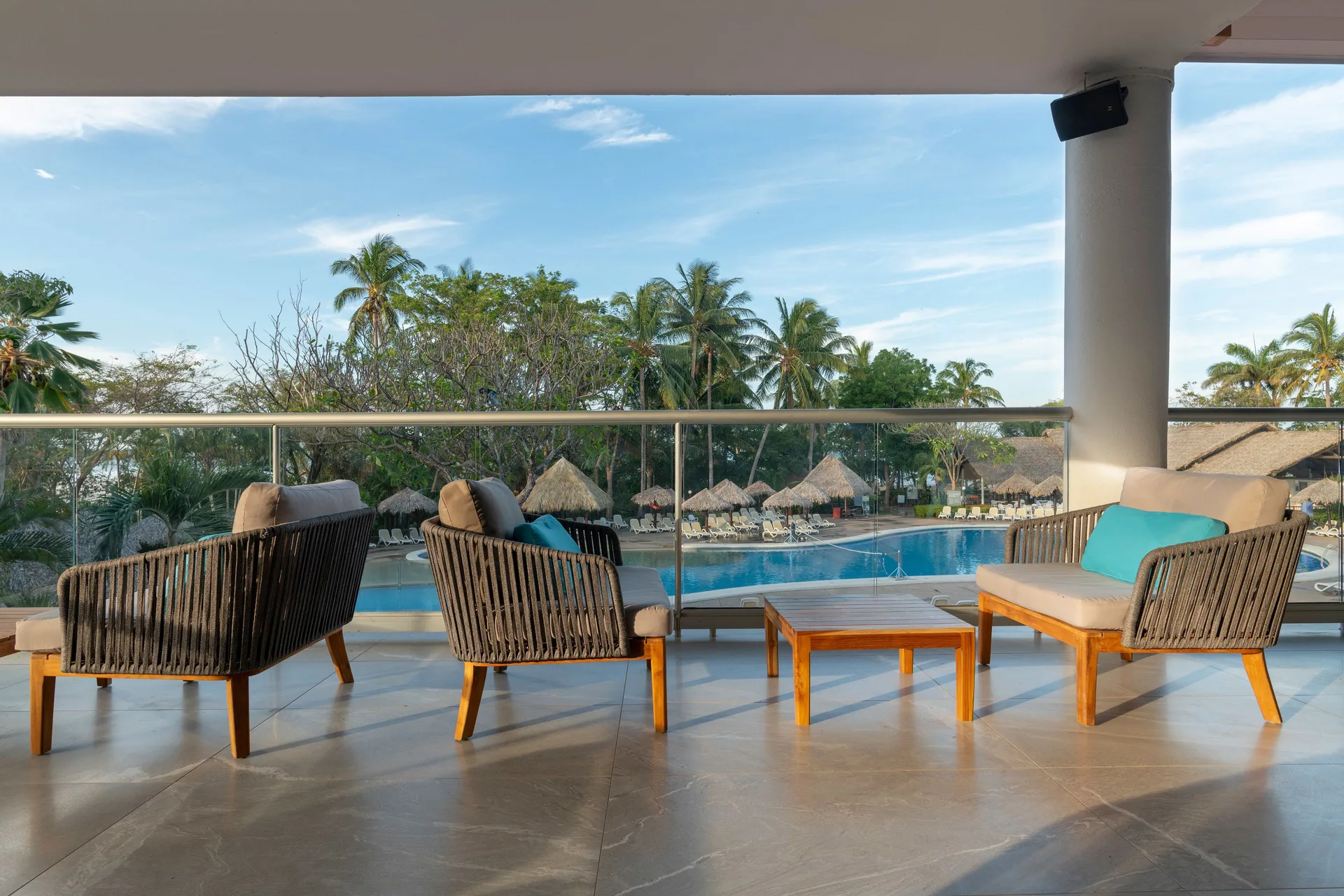 Terrace seating overlooking the pool and palms at Occidental Tamarindo.