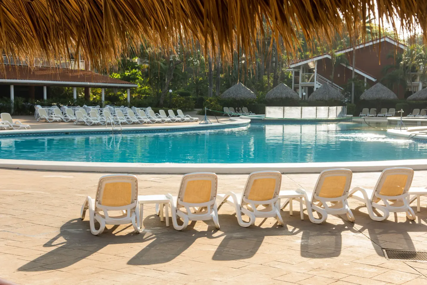 Poolside lounge chairs and turquoise water at Occidental Tamarindo.