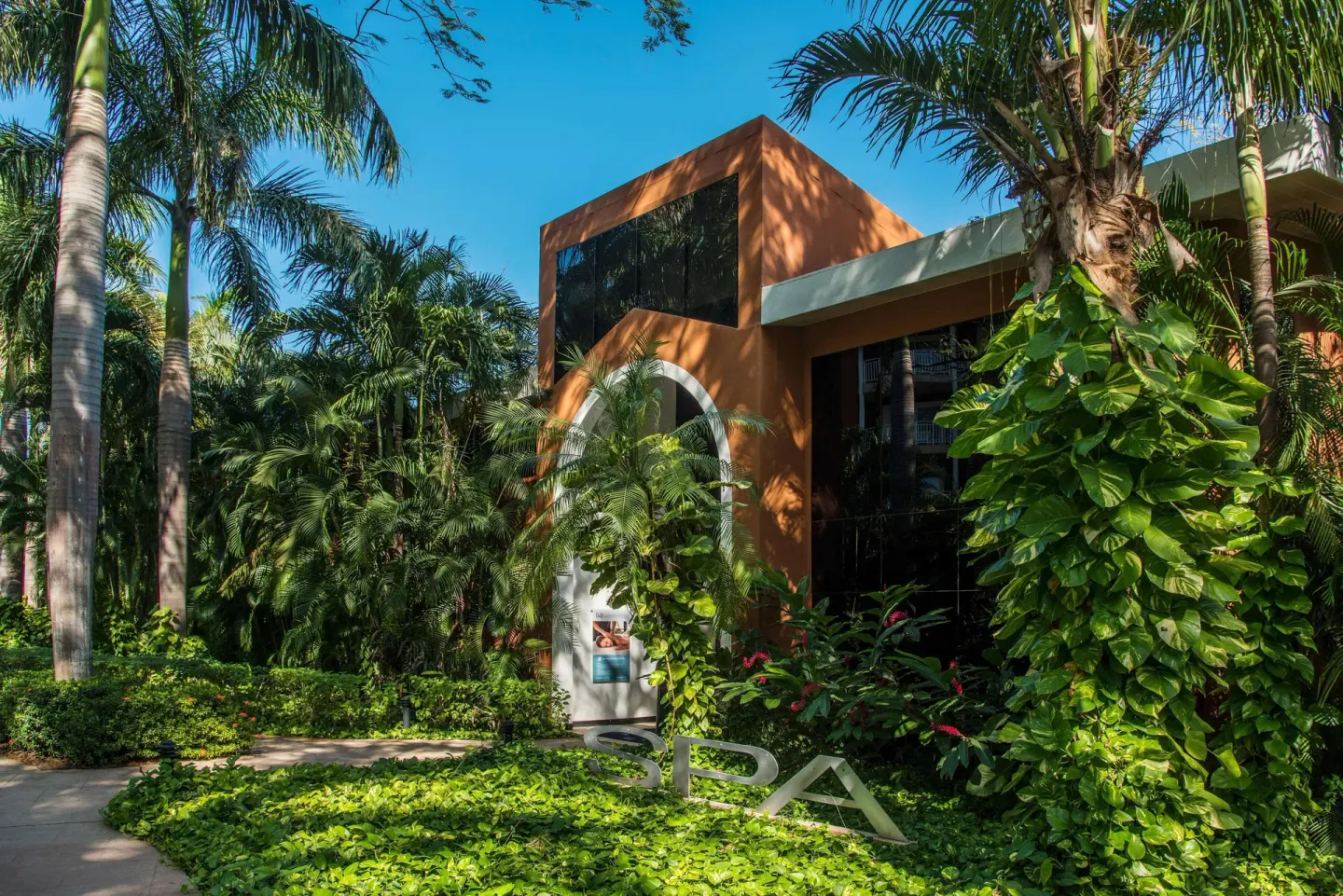 Spa entrance surrounded by palms and tropical plants at Occidental Tamarindo.