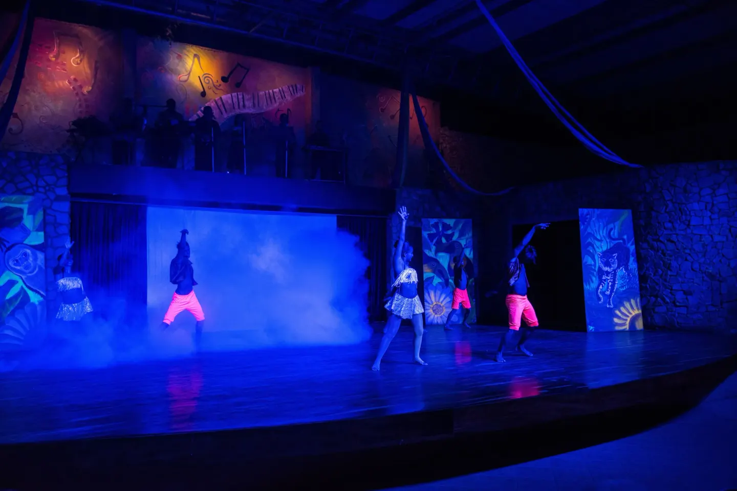 Stage dancers perform through blue haze and light at Occidental Tamarindo.