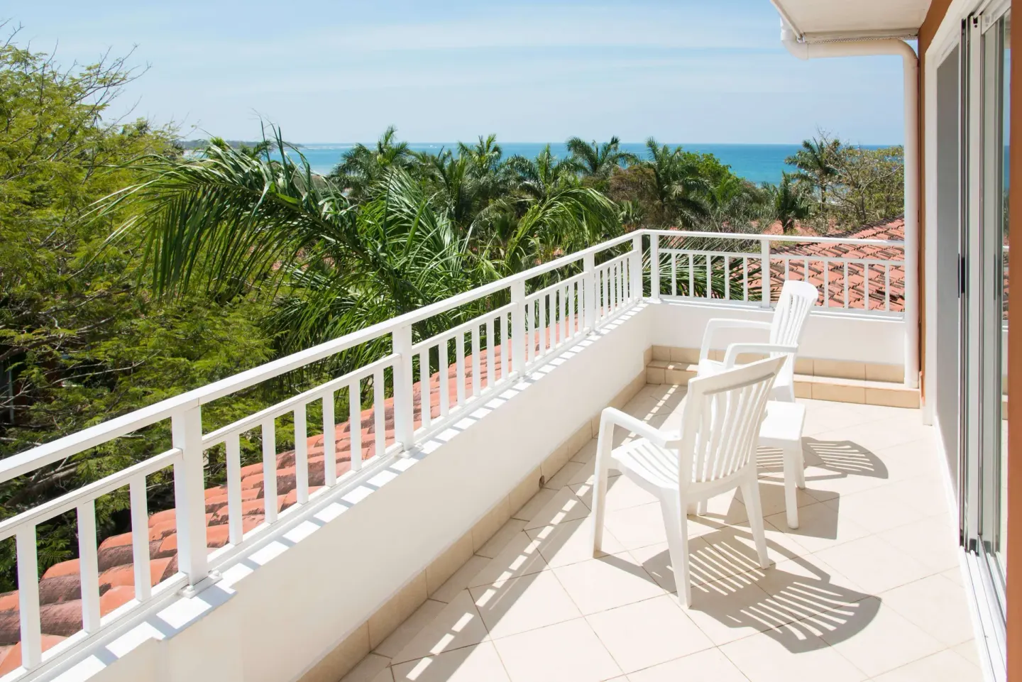 Duplex suite balcony with white chairs and ocean view at Occidental Tamarindo.
