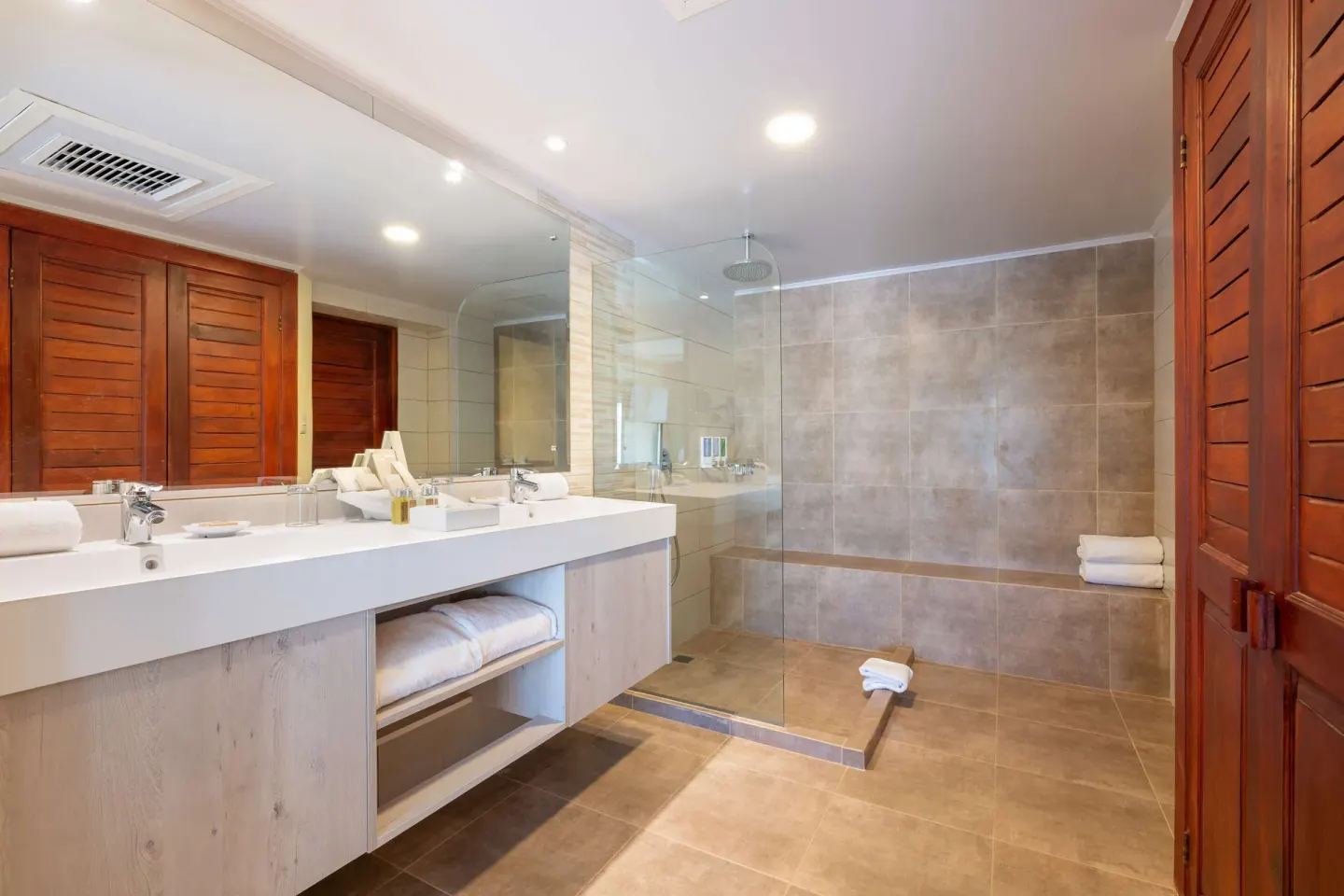 Duplex suite bathroom with double vanity and glass shower at Occidental Tamarindo.