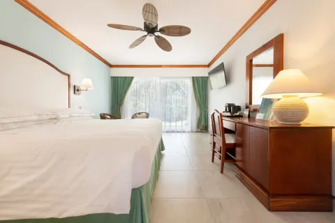 Superior Room king bed, desk, ceiling fan and balcony doors at Occidental Tamarindo.