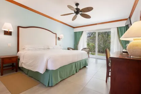 Superior Room king bed with dresser and garden-facing doors at Occidental Tamarindo.