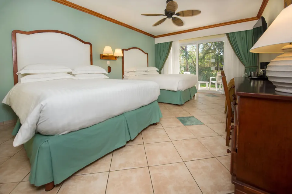 Superior Room with two beds, tiled floor and sliding glass doors at Occidental Tamarindo.