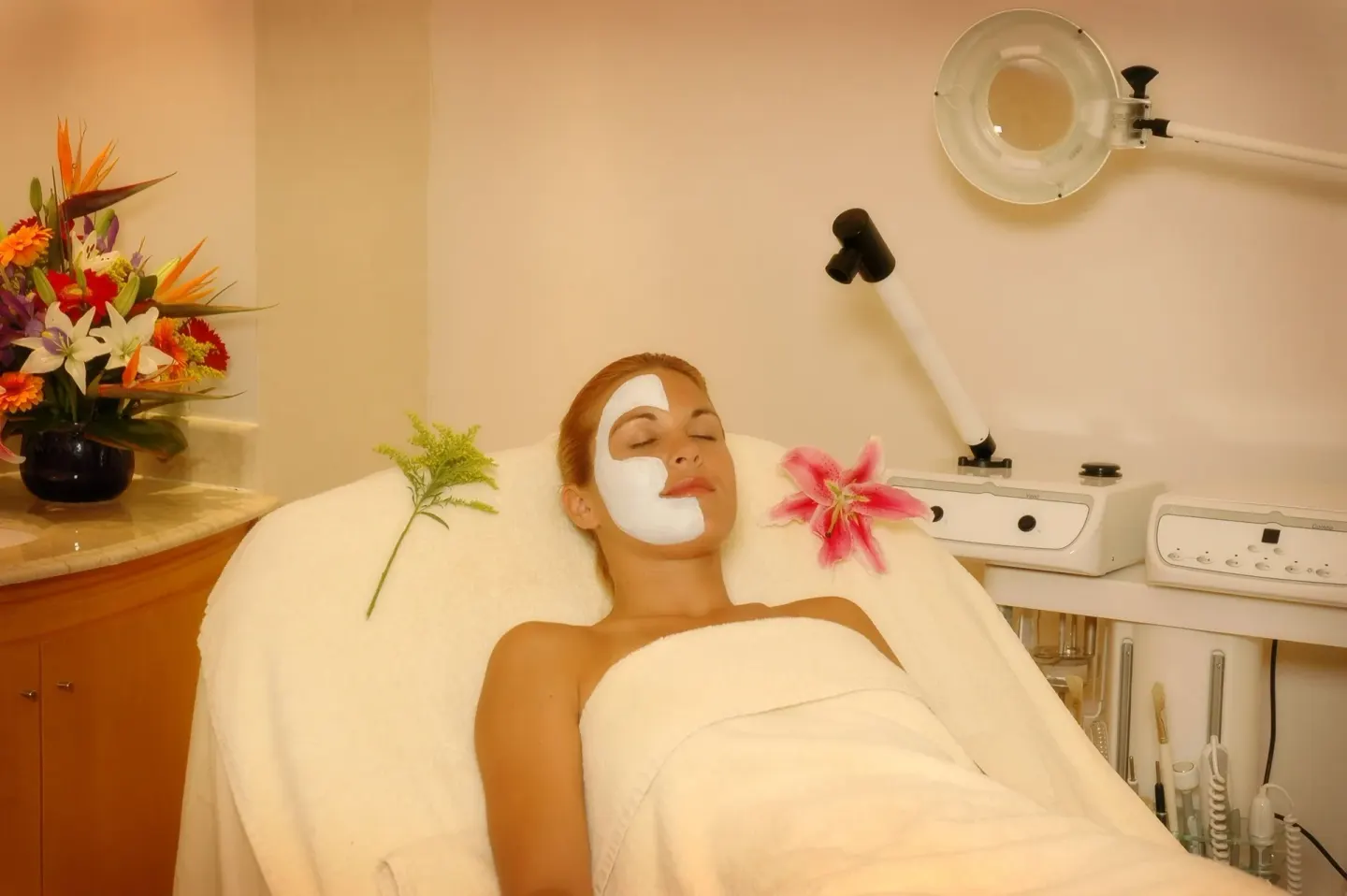 Facial treatment room with guest on spa bed at Occidental Tucancún.