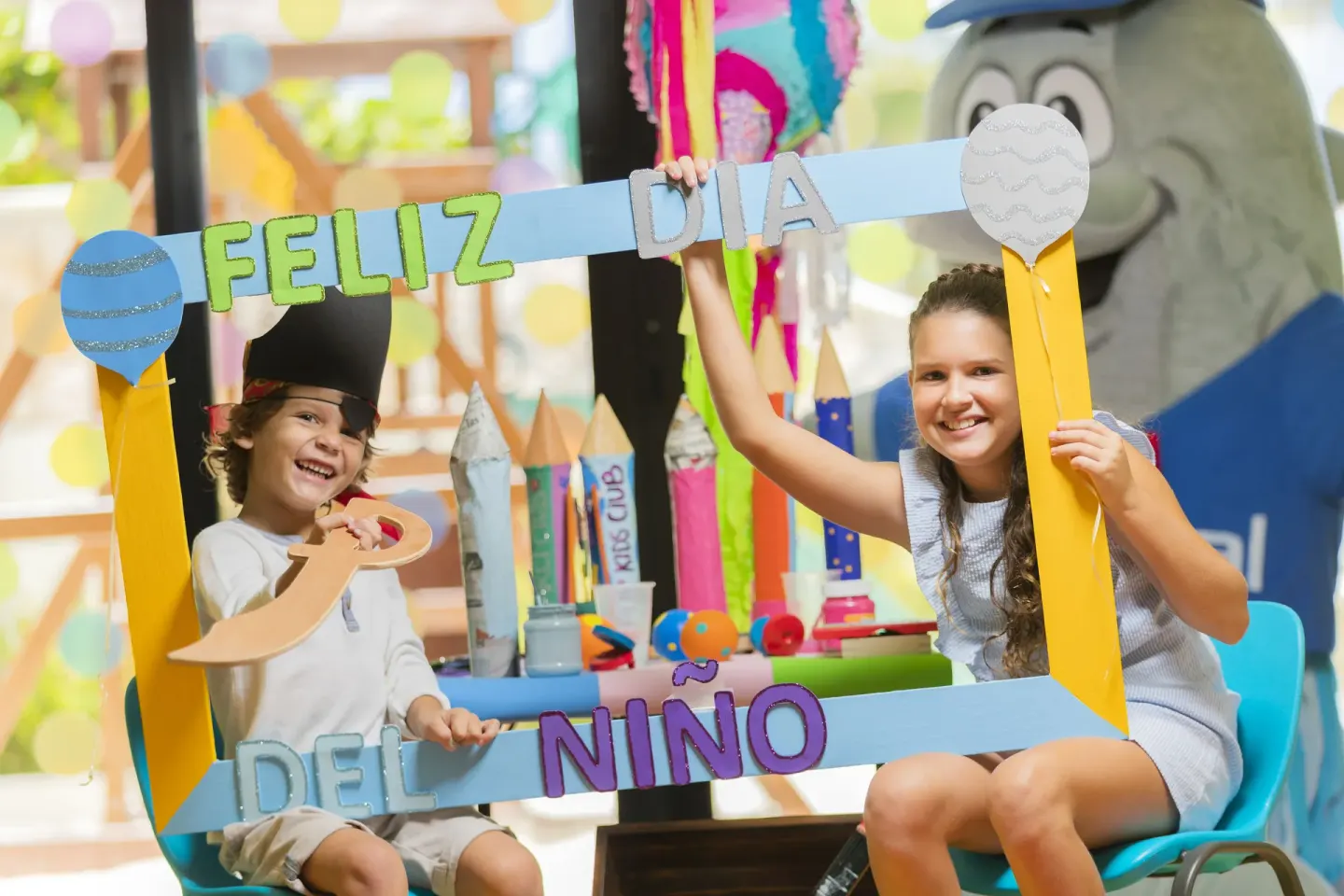 Children holding a colorful Children's Day frame in the kids club at Occidental Tucancún.