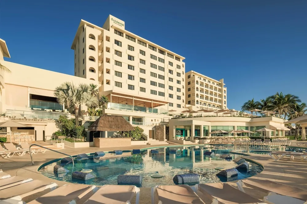 Main pool and resort towers with loungers at Occidental Tucancún.