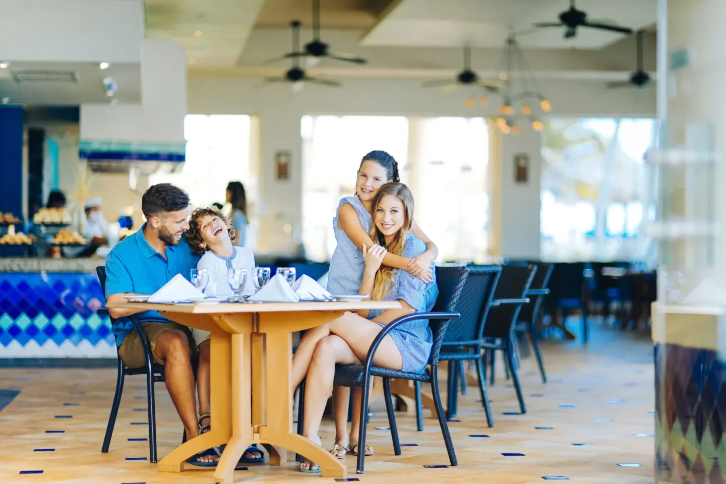 Family seated at a restaurant table inside Occidental Tucancún.