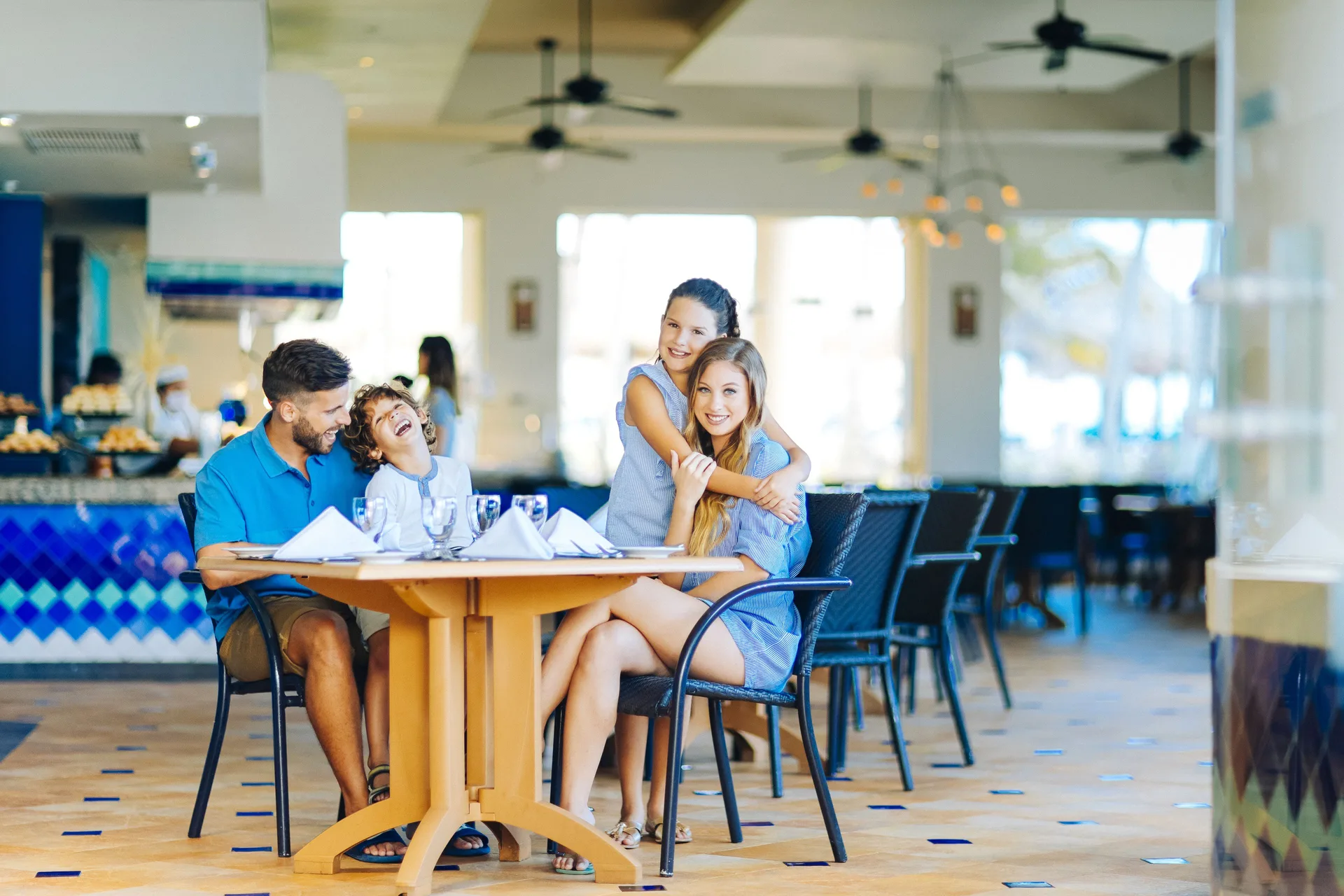 Family seated at a restaurant table inside Occidental Tucancún.