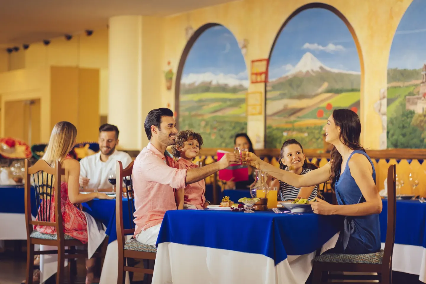 Family toasting at a Mexican-themed restaurant at Occidental Tucancún.