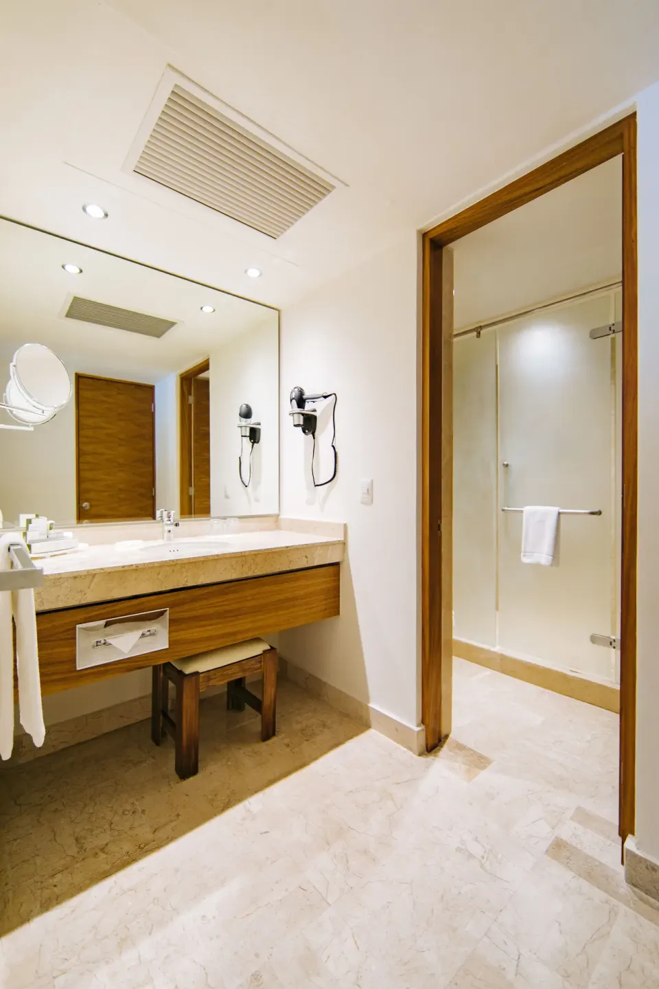 Premium Suite Oceanfront bathroom vanity and walk-in shower at Occidental Tucancún.