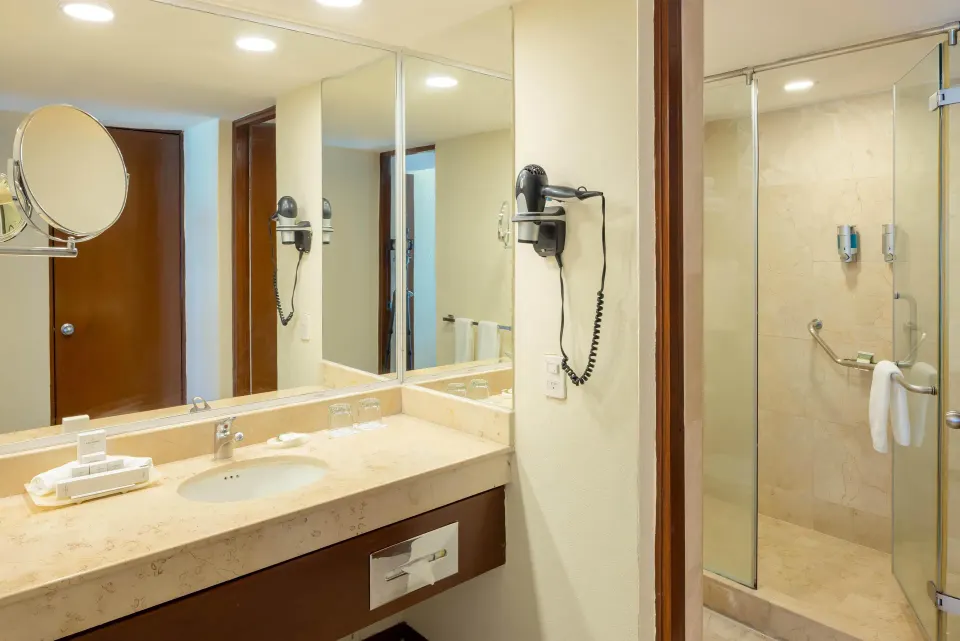 Premium Suite Oceanfront bathroom vanity and glass shower at Occidental Tucancún.