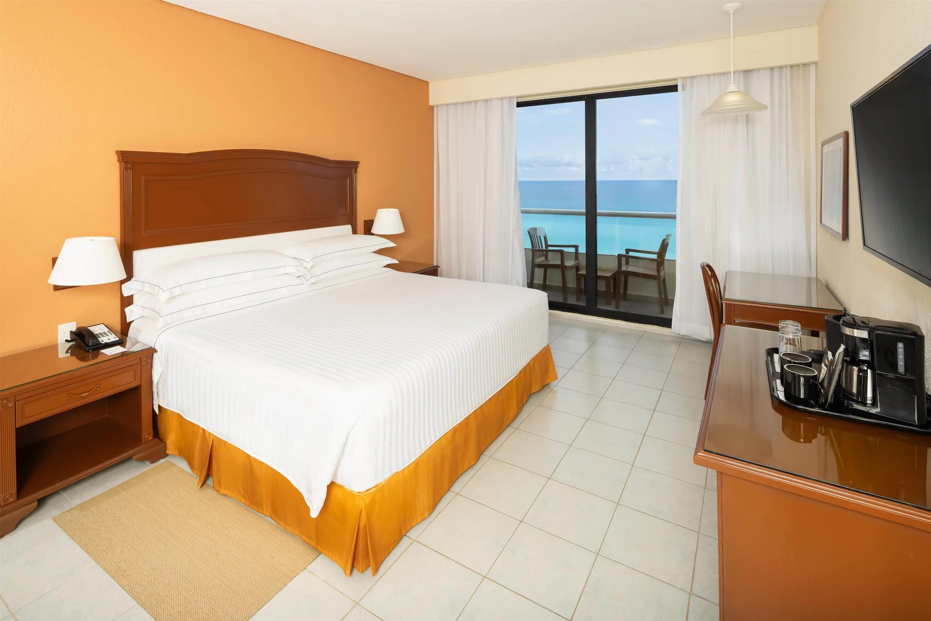 Room with sea view at Occidental Tucancún featuring king bed, balcony, and comfortable furnishings in Cancun's Hotel Zone.