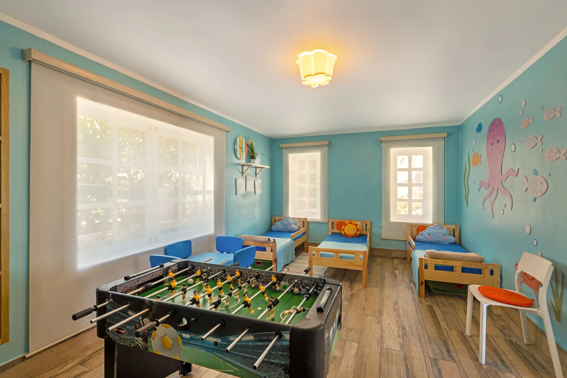Children's playroom with foosball and small beds at Ocean Blue & Sand Beach Resort.