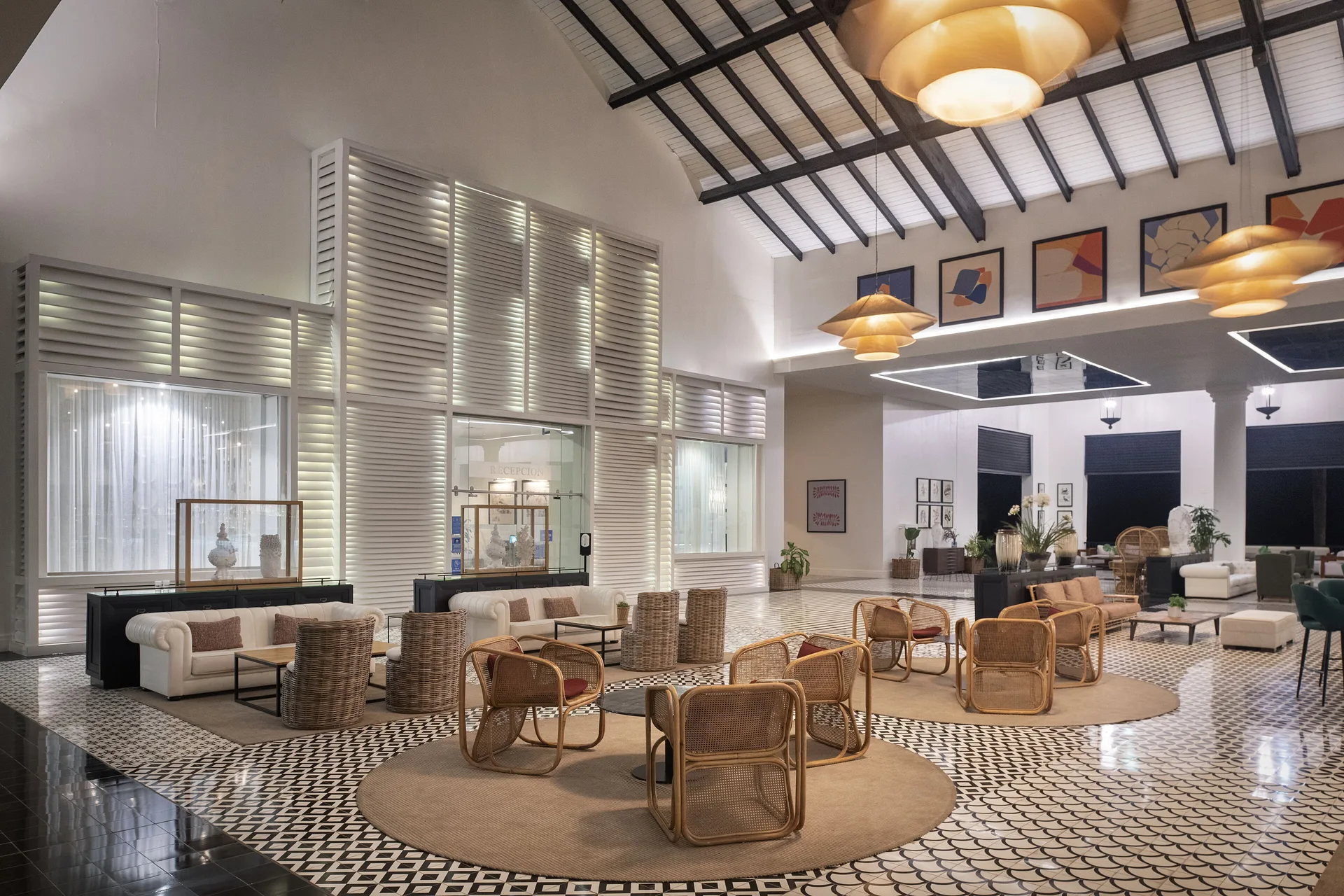 Lobby lounge with rattan chairs and patterned floors at Ocean Blue & Sand Beach Resort.