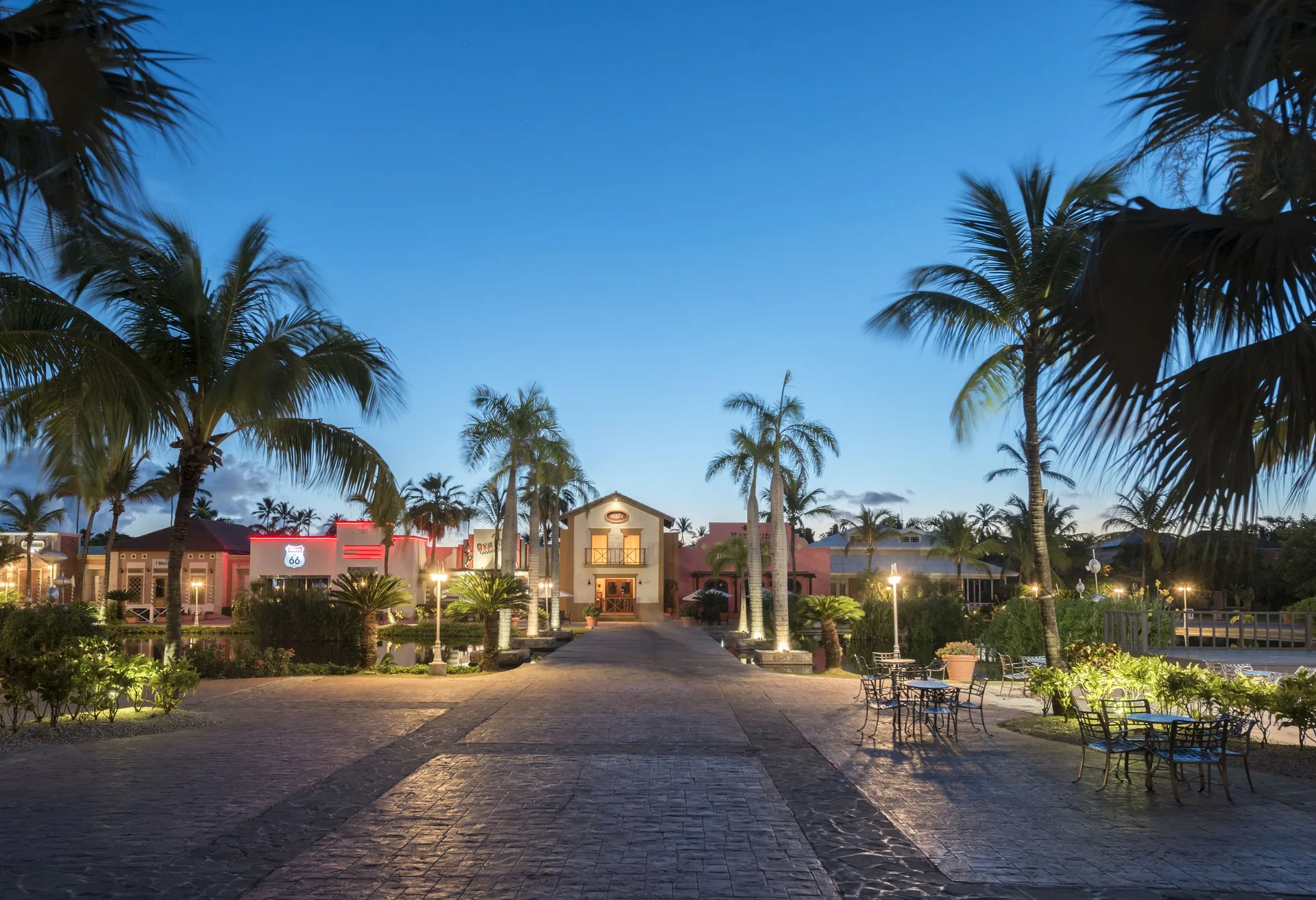 Palm-lined resort walkway at dusk at Ocean Blue & Sand Beach Resort.