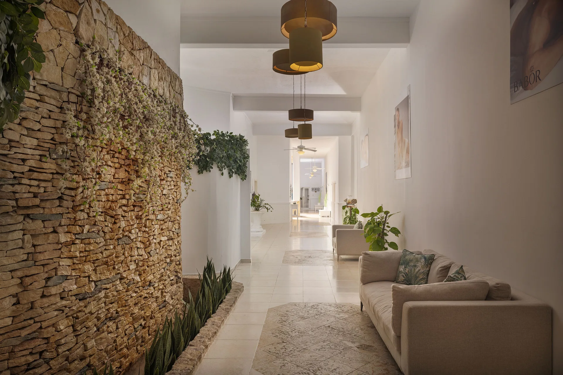 Spa corridor with stone wall and sofa at Ocean Blue & Sand Beach Resort.