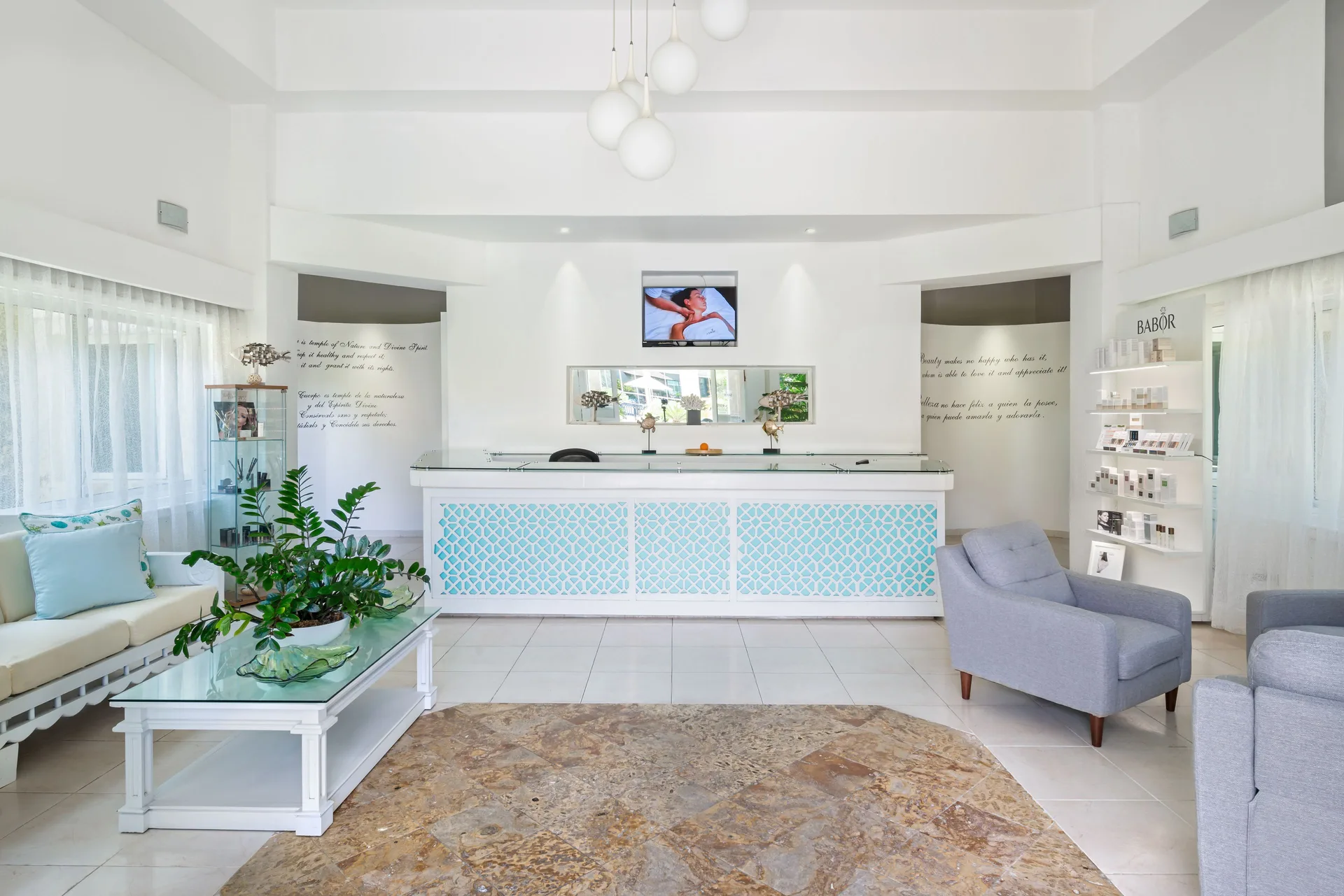 Spa reception lounge with white seating at Ocean Blue & Sand Beach Resort.