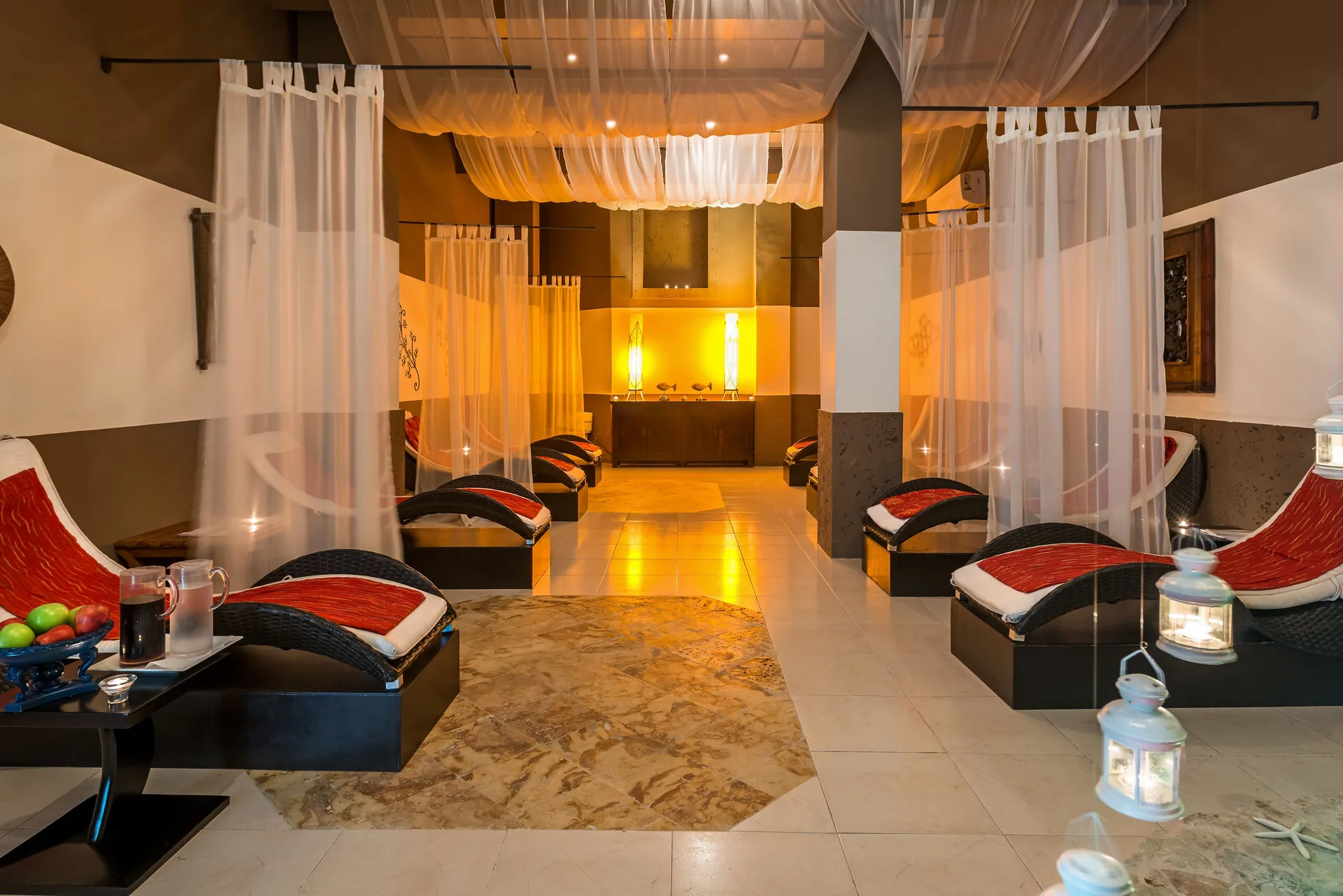 Spa relaxation lounge with curtained daybeds at Ocean Blue & Sand Beach Resort.