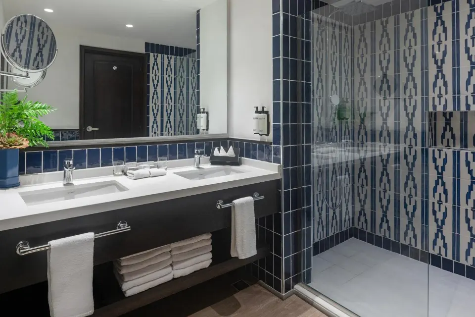 Junior Suite bathroom with double vanity and tiled shower at Ocean Blue & Sand Beach Resort.