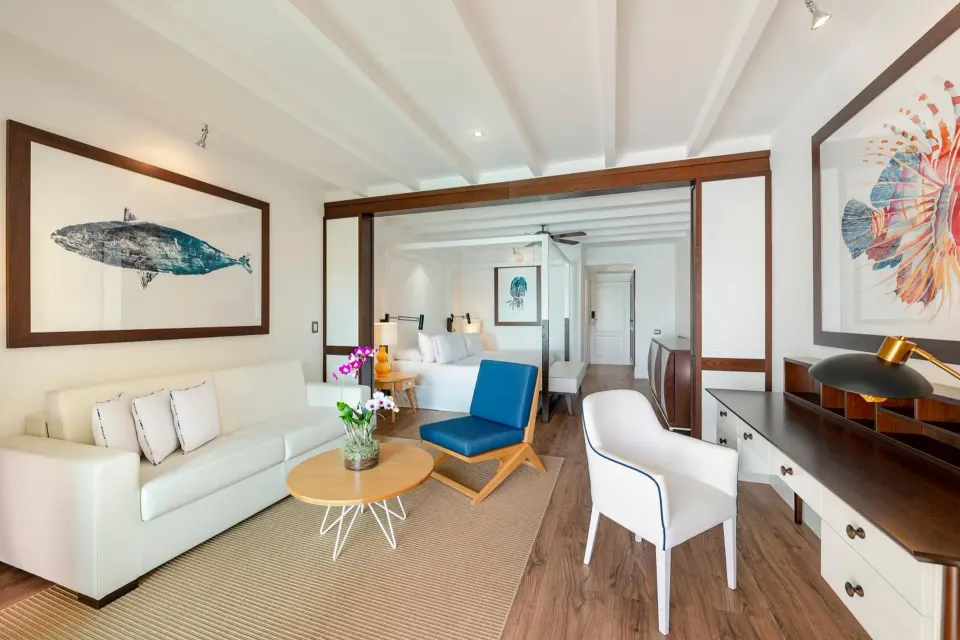 Junior Suite living area with sofa bed and king bed at Ocean Blue & Sand Beach Resort.