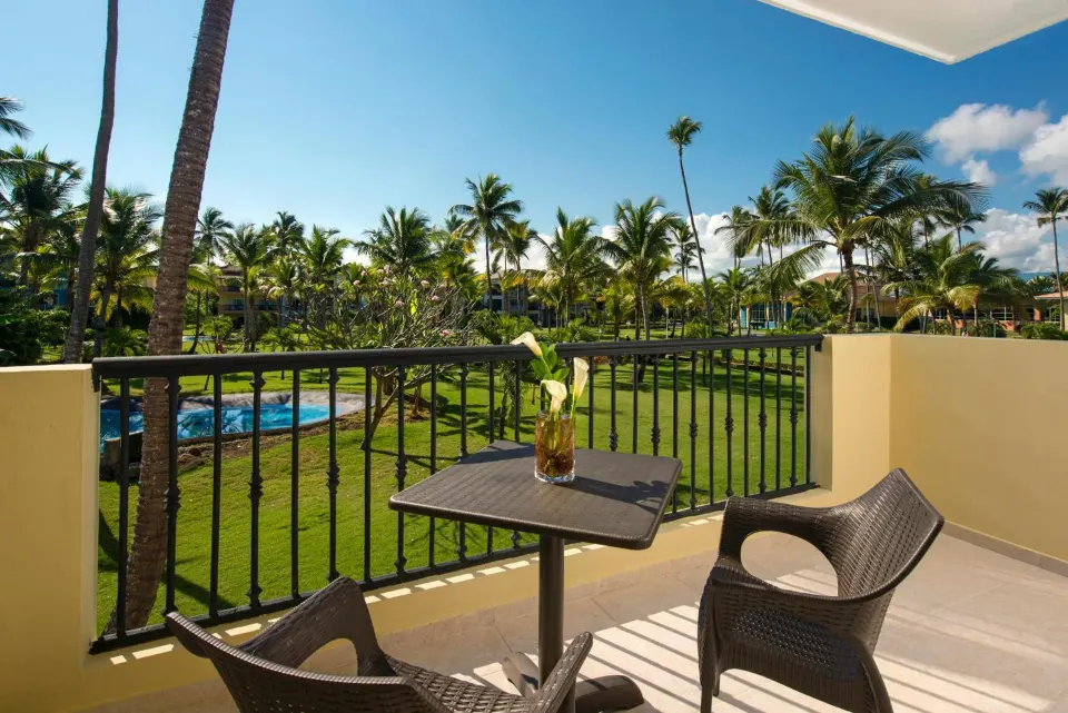 Junior Suite terrace with chairs and garden view at Ocean Blue & Sand Beach Resort.
