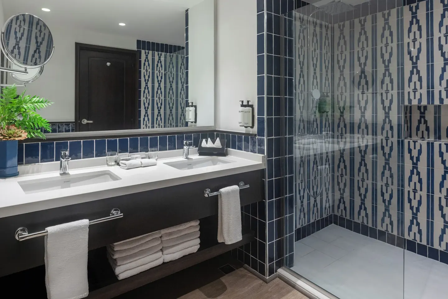 Junior Suite Elegance Pool View bathroom vanity and glass shower at Ocean Blue & Sand Beach Resort.