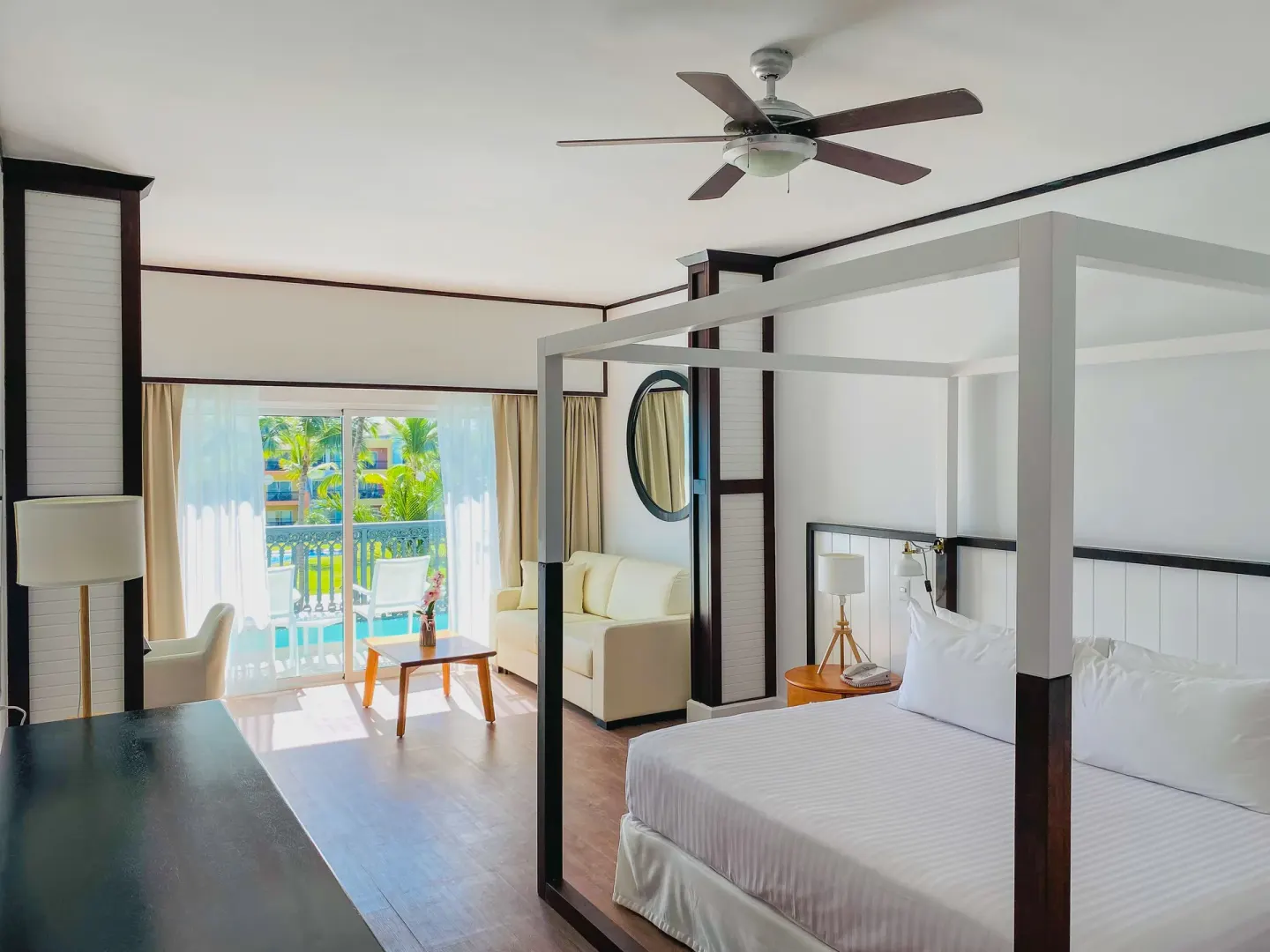Junior Suite Nature View with canopy bed and balcony doors at Ocean Blue & Sand Beach Resort.