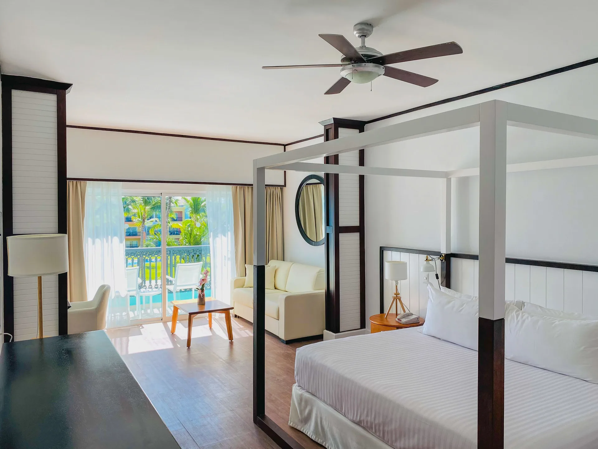 Junior Suite Nature View with canopy bed and balcony doors at Ocean Blue & Sand Beach Resort.