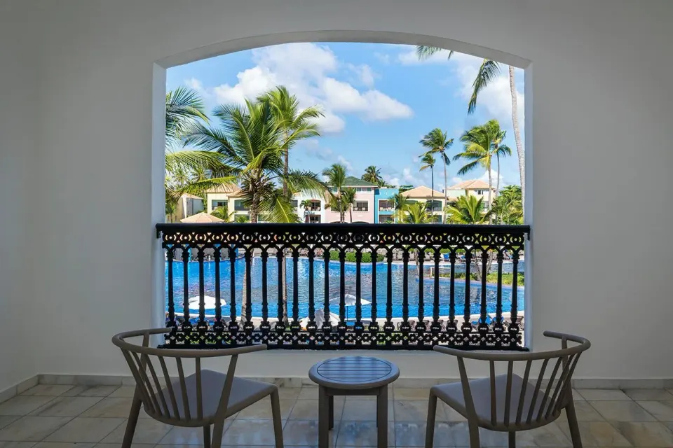 Junior Suite Pool View balcony at Ocean Blue & Sand Beach Resort with two chairs facing the pool.