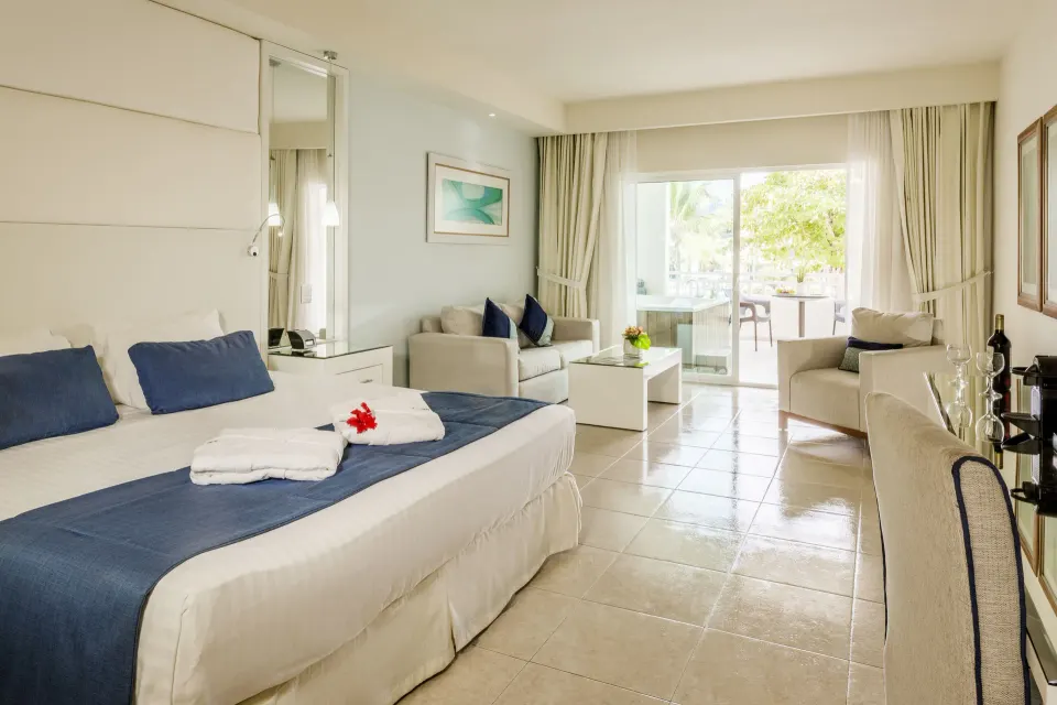 Privilege Honeymoon Junior Suite with king bed and balcony doors at Ocean Blue & Sand Beach Resort.