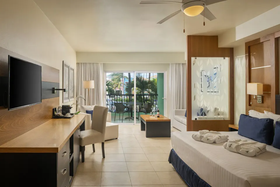 Privilege Junior Suite Nature View king bed, desk, and balcony at Ocean Blue & Sand Beach Resort.