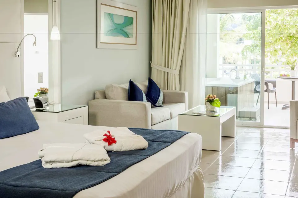Privilege Junior Suite Nature View bed and sitting area at Ocean Blue & Sand Beach Resort.