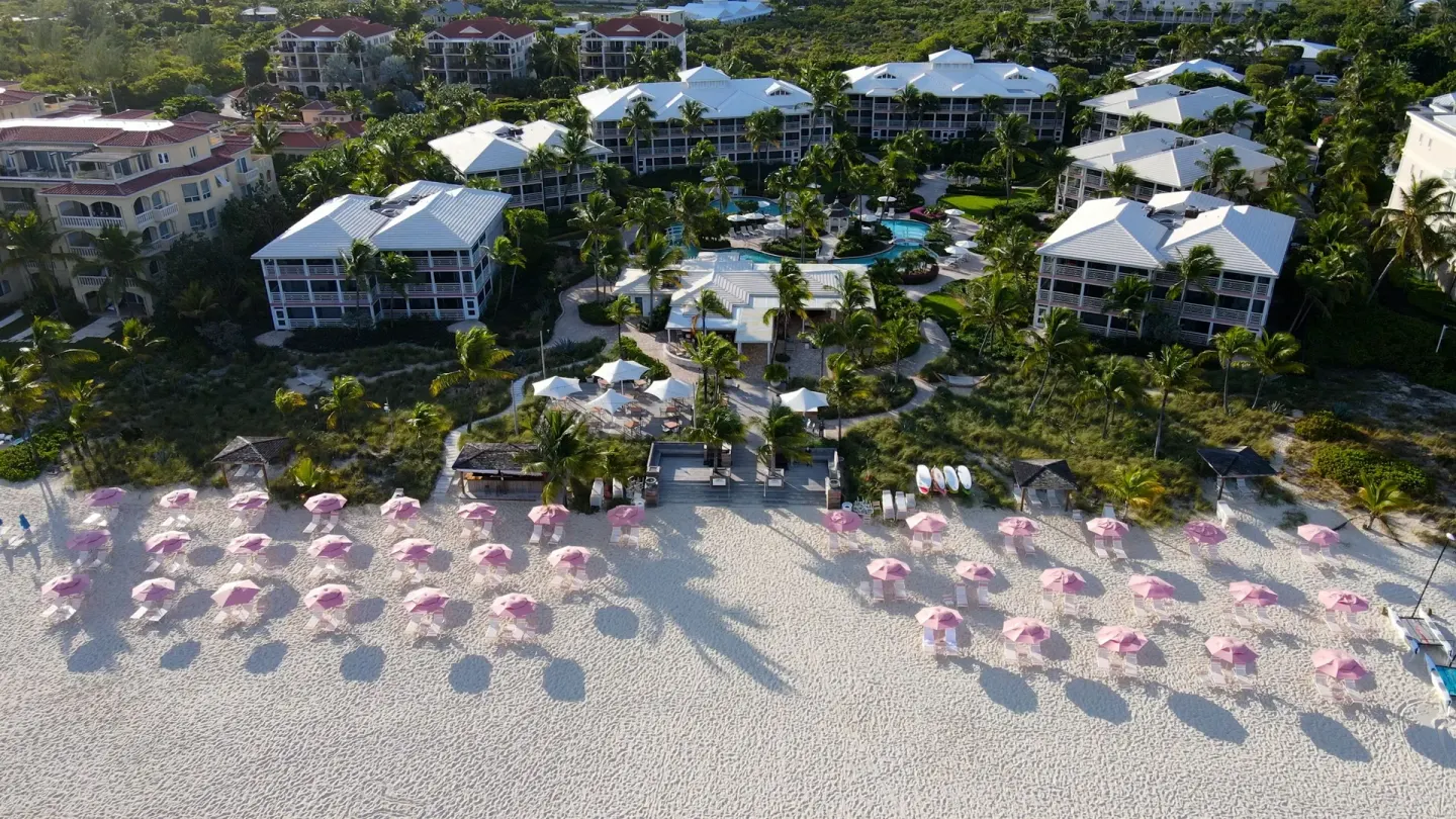 Aerial view of beachfront umbrellas and resort grounds at Ocean Club West, Grace Bay Beach.