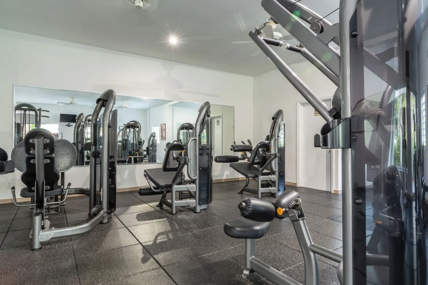 Fitness room with weight machines and wall mirrors at Ocean Club West, Grace Bay Beach.