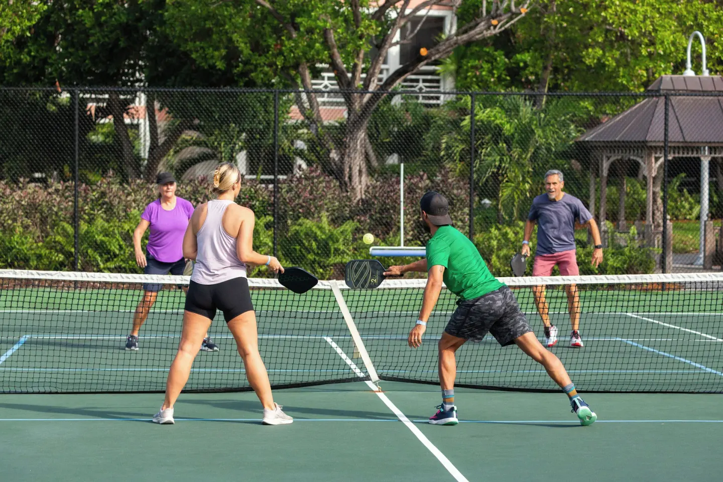 Four guests play pickleball on a court at Ocean Club West, Grace Bay Beach.