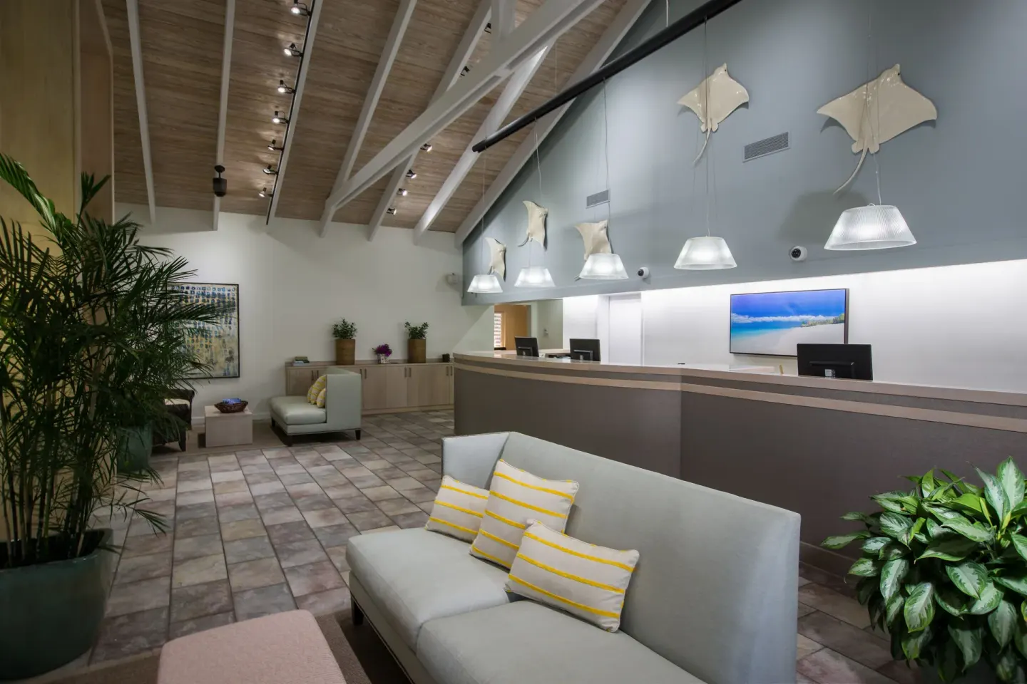 Reception lobby with seating, front desk, and wall decor at Ocean Club West, Grace Bay Beach.