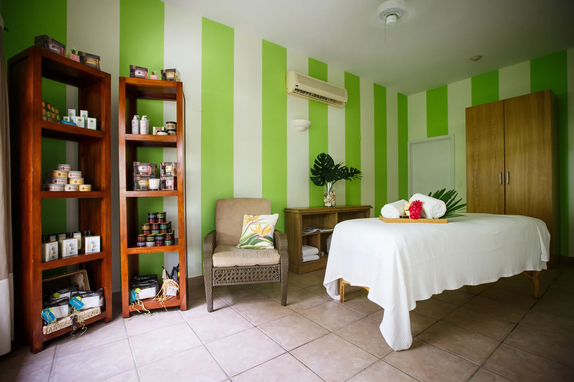 Spa treatment room with massage table and product shelves at Ocean Club West, Grace Bay Beach.