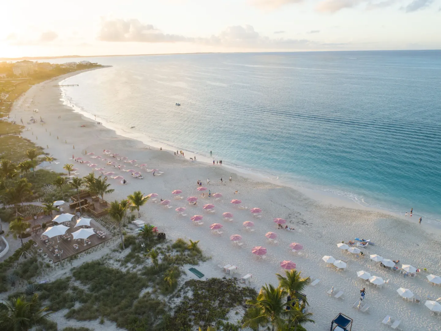 Sunlit aerial view of Grace Bay Beach with umbrellas at Ocean Club West, Grace Bay Beach.