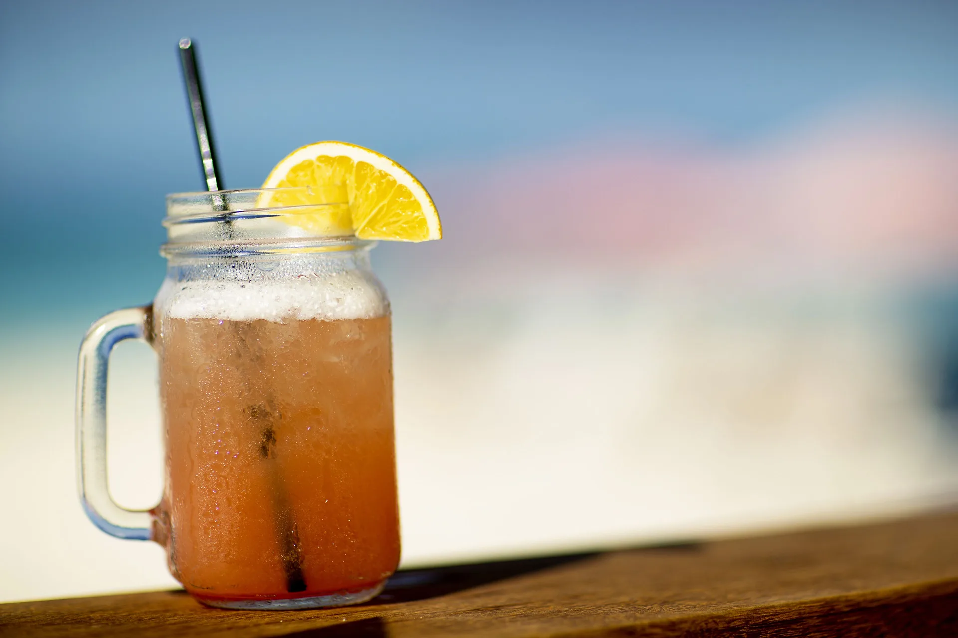 Iced cocktail in a mason jar with lemon garnish at Ocean Club West, Grace Bay Beach.