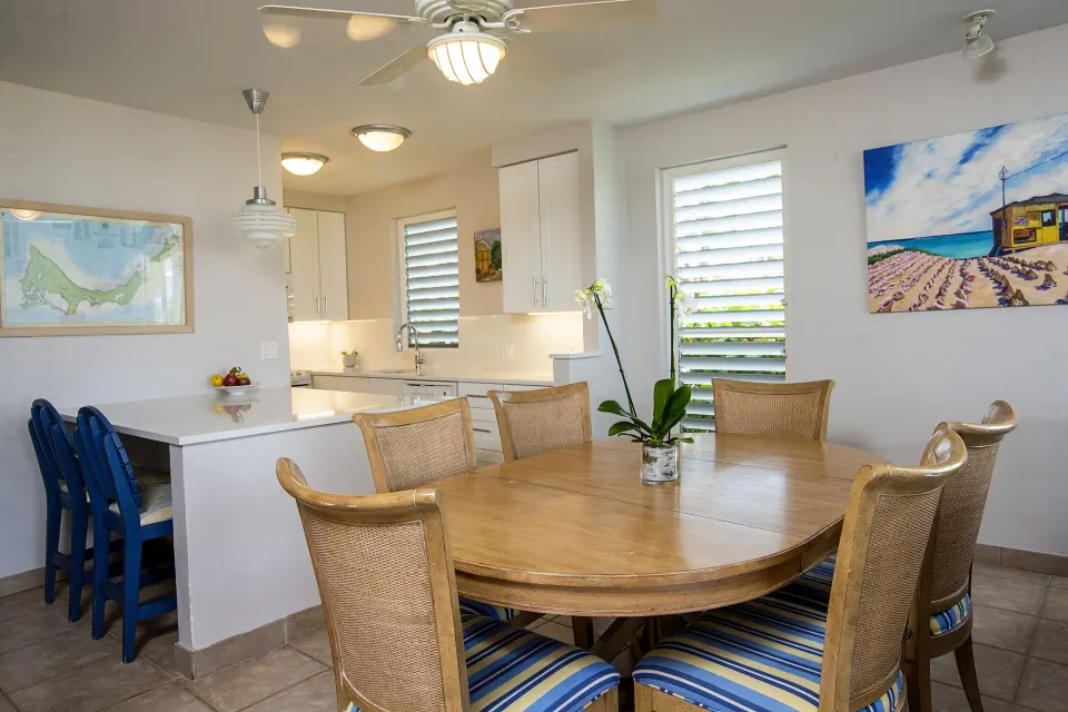Dining table and kitchen in a beachfront deluxe suite at Ocean Club West, Grace Bay Beach.