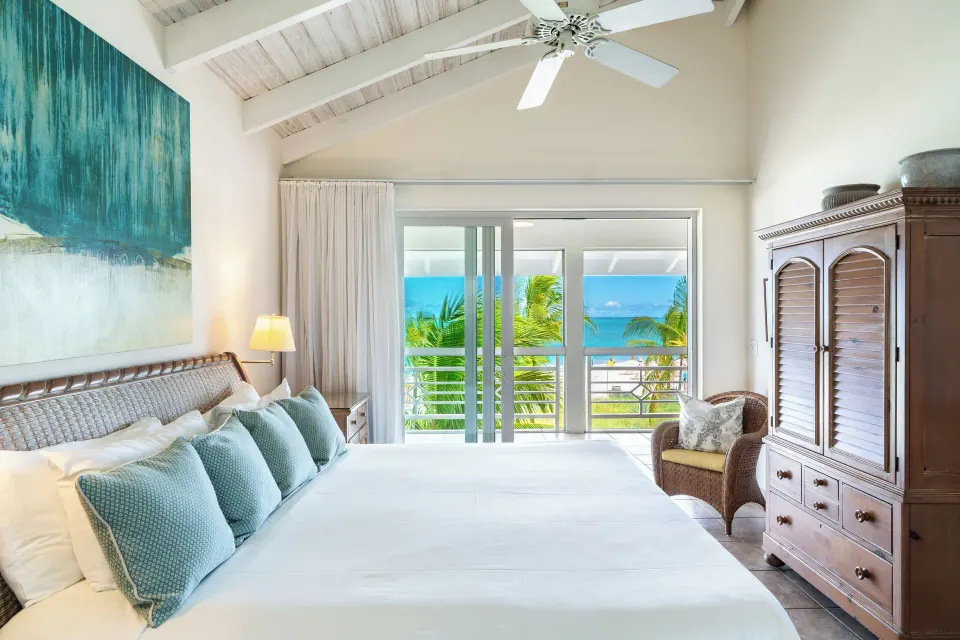 King bedroom with ocean-facing balcony in a deluxe suite at Ocean Club West, Grace Bay Beach.