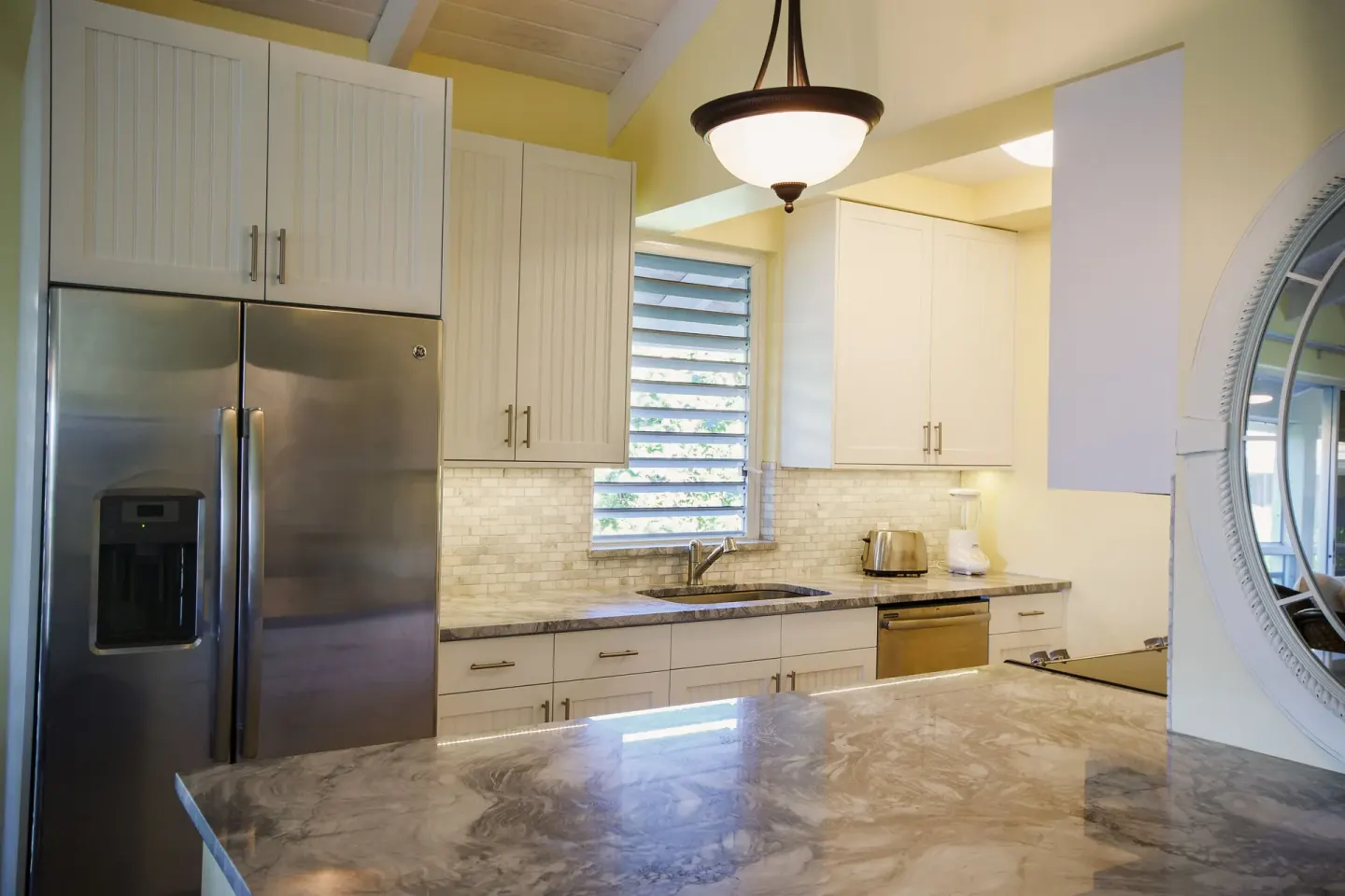 Kitchen with stainless refrigerator in a beachfront deluxe suite at Ocean Club West, Grace Bay Beach.