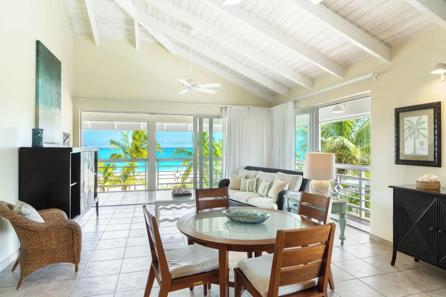 Living and dining area with beachfront views in a deluxe suite at Ocean Club West, Grace Bay Beach.