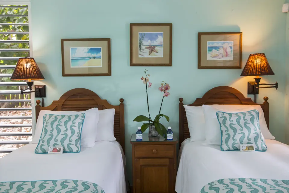Twin beds in a beachfront two-bedroom deluxe suite at Ocean Club West, Grace Bay Beach.